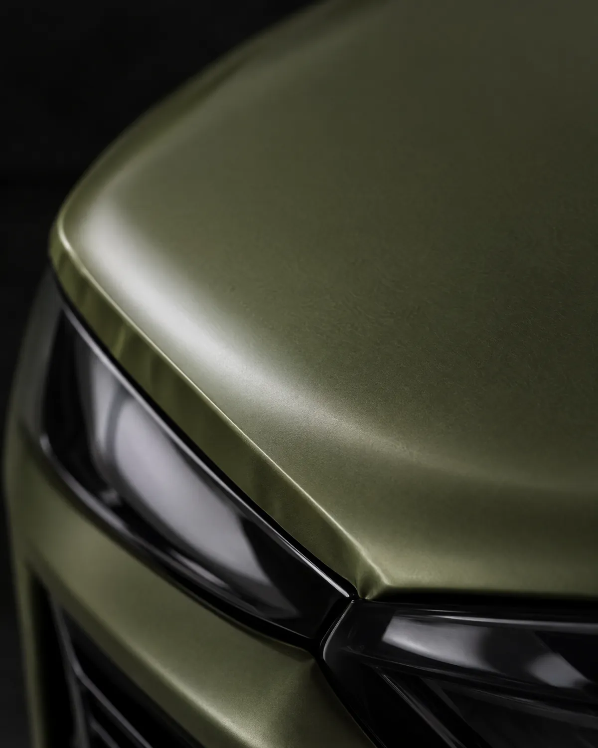 Macro of satin olive colour paint protection film wrapped around a bonnet edge