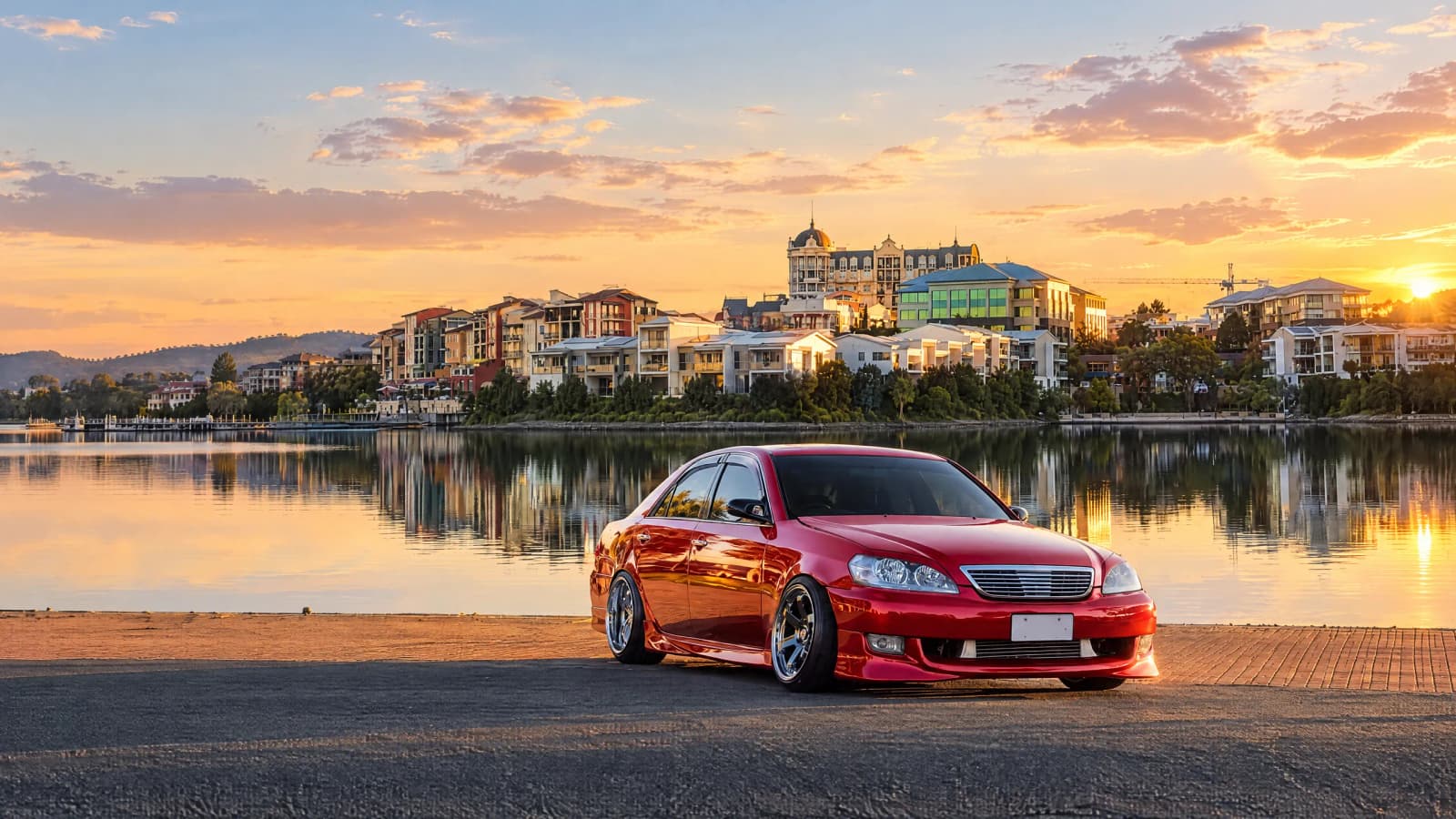 Candy red Toyota Mark II gloss wrap by the water at sunset